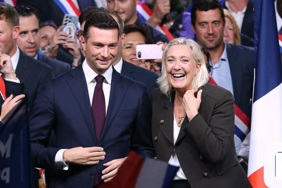 Marine Le Pen (à droite), présidente du groupe parlementaire d'extrême droite Rassemblement National (RN) et candidate à l'élection présidentielle française de 2027, et Jordan Bardella (à gauche), président du RN, réagissent sur scène à la fin d'un meeting marquant le début de la nouvelle année politique à Hénin-Beaumont, dans le nord de la France, le 13 septembre 2026.
