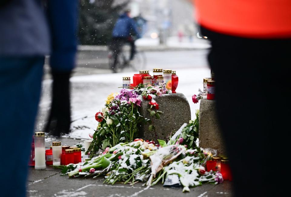 Des personnes se tiennent devant un mémorial improvisé le 16 février 2025 sur les lieux où une voiture a foncé dans la foule dans la ville de Munich, dans le sud de l'Allemagne.