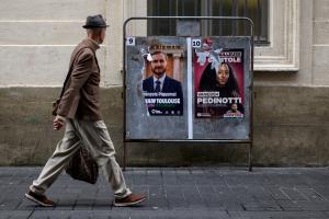 Un piéton passe les affiches des candidats à la mairie François Piquemal (député LFI) et de Vanessa Pedinotti (Révolution Permanente), à Toulouse, le 9 mars 2026.