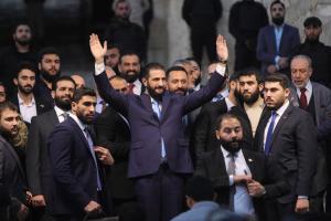 Le président syrien Ahmed al-Charaa salue la foule aux portes de la citadelle d'Alep, le 29 novembre 2025, lors des célébrations marquant le premier anniversaire de son arrivée au pouvoir.