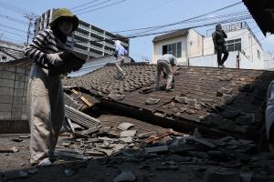 Des personnes travaillent sur le site d'un immeuble effondré à Yatsushiro, dans la préfecture de Kumamoto, le 3 août 2026, après le séisme qui a frappé le sud-ouest du Japon le 28 juillet. 