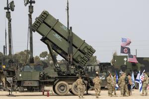 Des officiers de l'armée américaine se tiennent devant un système de défense antimissile Patriot américain lors de l'exercice militaire israélo-américain conjoint « Juniper Cobra » sur la base aérienne de Hatzor, le 8 mars 2018.