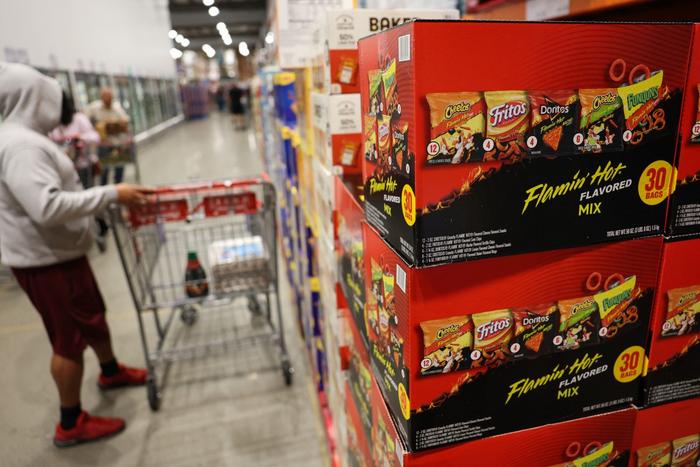 Des boîtes de snacks, notamment des Cheetos, des Fritos, des Doritos et des Funyuns, sont présentées à côté d'autres produits alimentaires emballés dans un entrepôt-magasin de Hawthorne, en Californie, le 2 décembre 2025.