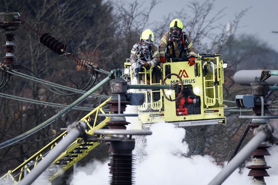 Des pompiers éteignent les flammes d'un incendie qui s'est déclaré dans une sous-station électrique alimentant l'aéroport d'Heathrow à Hayes, dans l'ouest de Londres, le 21 mars 2025.