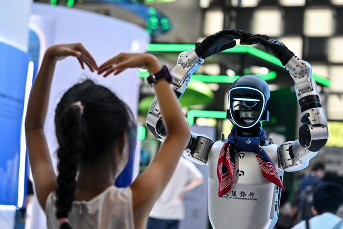 Une fille joue avec un robot lors de la World Artificial Intelligence Conference (WAIC) au Shanghai World Expo and Convention Center, à Shanghai, le 28 juillet 2025. (Image d'illustration)