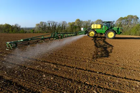 Un agriculteur français pulvérise l'herbicide à base de glyphosate « Roundup 720 », dans un champ de maïs près d'un parc éolien.