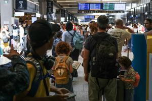Des voyageurs attendent leur train à la gare Montparnasse.