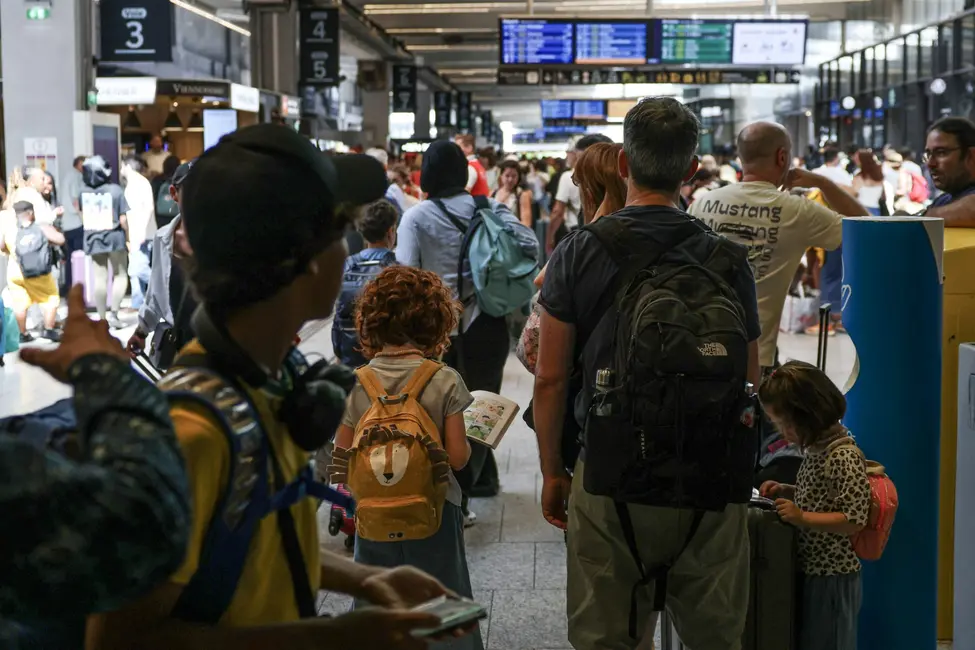 Des voyageurs attendent leur train à la gare Montparnasse.