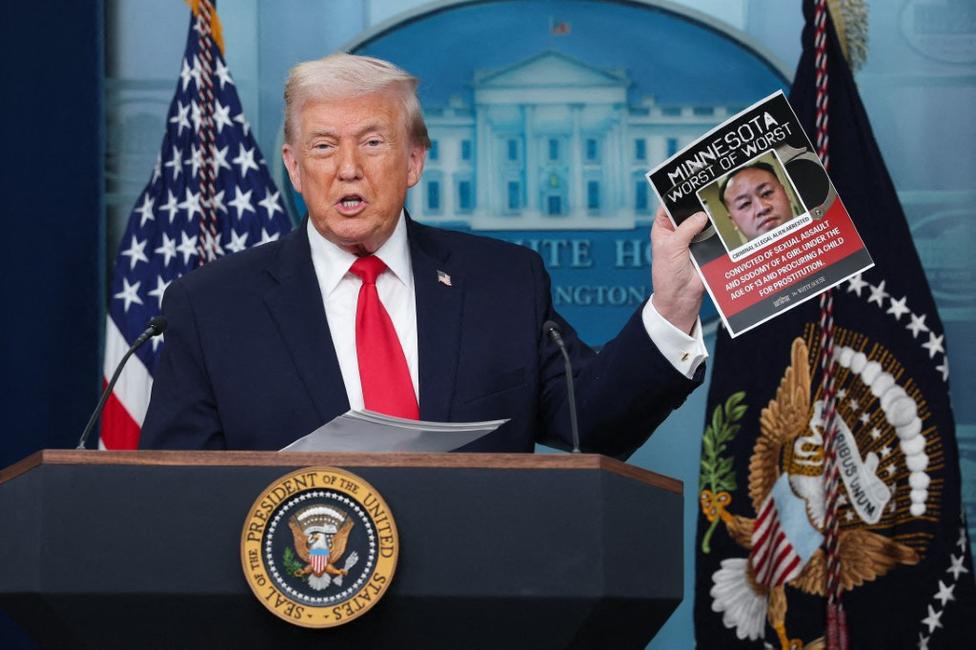Le président américain Donald Trump brandit la photo d'un homme qu'il décrit comme un immigré clandestin arrêté dans le Minnesota, lors d'une conférence de presse dans la salle de presse James S. Brady de la Maison Blanche, le 20 janvier 2026.