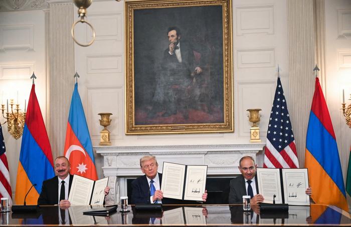 Le président américain Donald Trump (au centre), le président azerbaïdjanais Ilham Aliyev (à gauche) et le Premier ministre arménien Nikol Pashinyan présentent l'accord qu'ils ont signé dans la salle à manger d'État de la Maison Blanche à Washington, DC, le 8 août 2025.