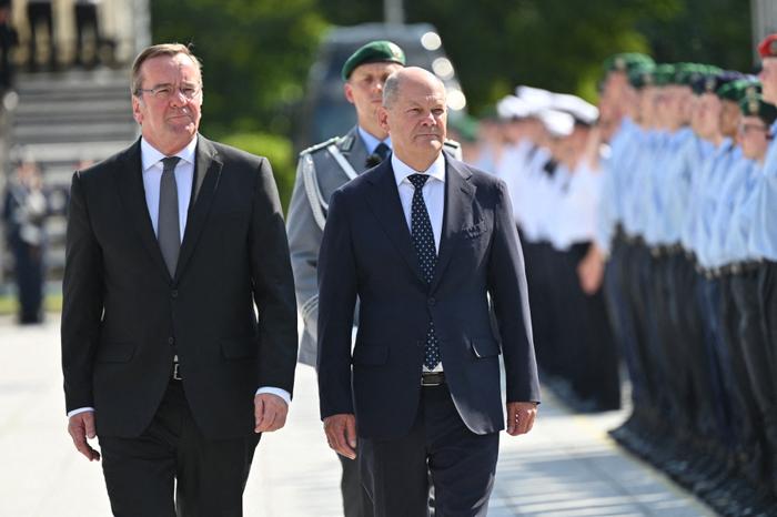 Le ministre allemand de la Défense Boris Pistorius et le chancelier allemand Olaf Scholz passent en revue une garde d'honneur lors de la cérémonie de prestation de serment des recrues de la Bundeswehr en souvenir de la résistance allemande, le 20 juillet 2024 à Berlin.