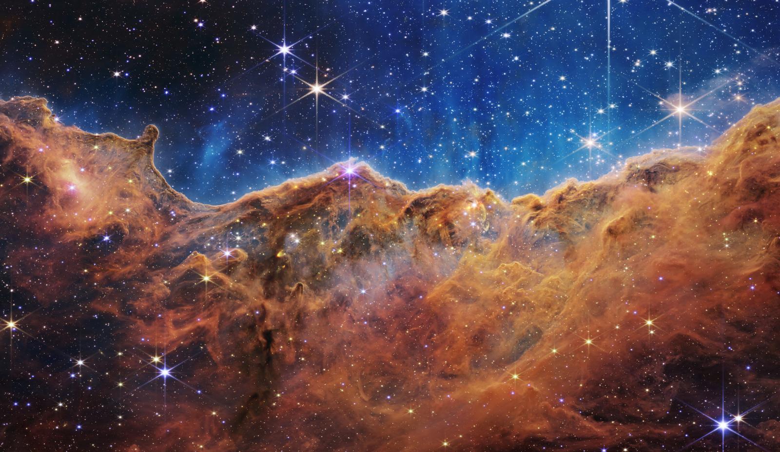 Cette image publiée par la NASA le 12 juillet 2022 depuis le télescope spatial James Webb montre des étoiles scintillantes sur le bord d'une jeune région de formation d'étoiles proche appelée NGC 3324 dans la nébuleuse de la Carène.