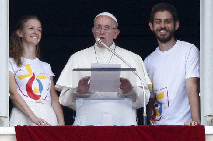Le pape François entouré de deux jeunes polonais alors qu'il annonce l'ouverture officielle des inscriptions en ligne pour le JMJ 2016 depuis la place Saint-Pierre au Vatican le 26 Juillet 2015.