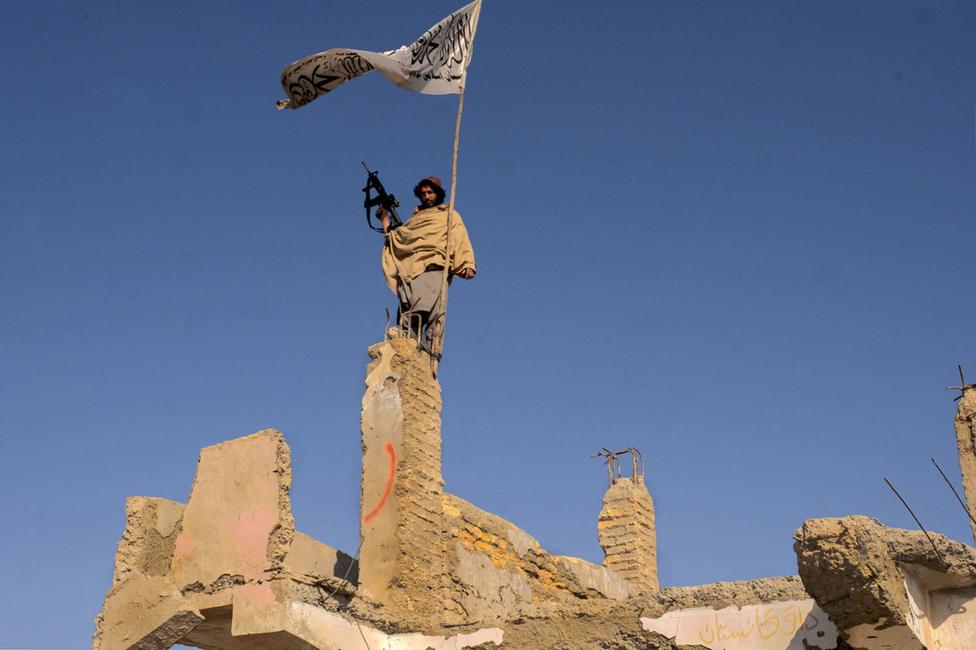 Un combattant brandit le drapeau taliban sur les ruines de bâtiments détruits par les frappes américaines et britanniques. Sangin, Province du Helmand, Afghanistan, 30 novembre 2021.
© Alfred Yaghobzadeh